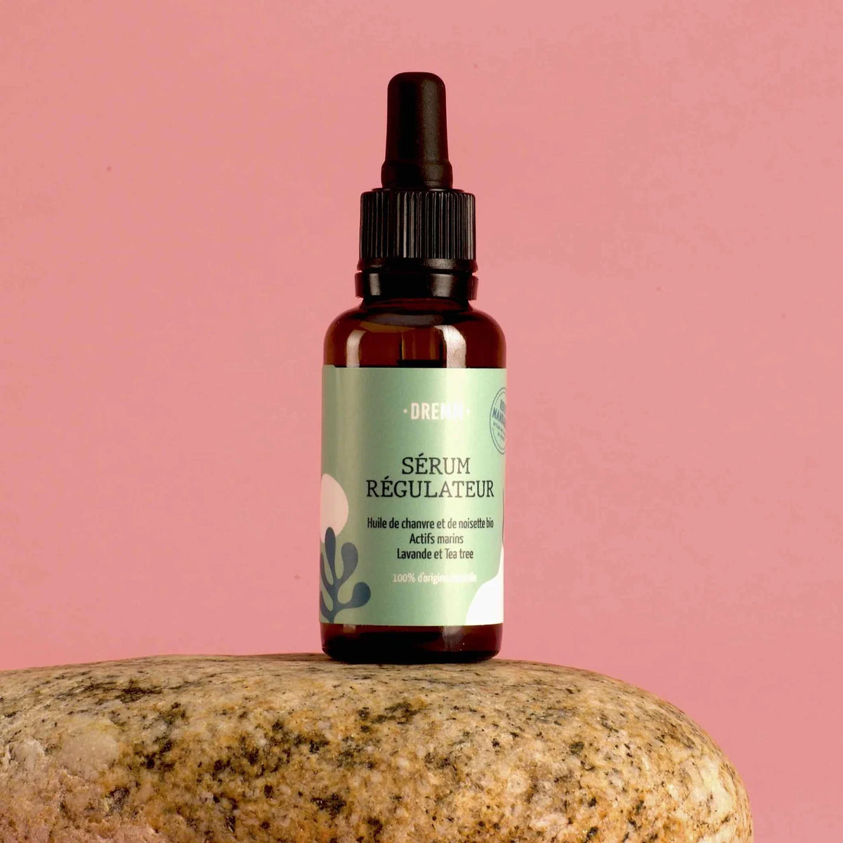 Le sérum visage régulateur aux actifs marins pour  les peaux mixtes à grasses sur un fond rose uni
