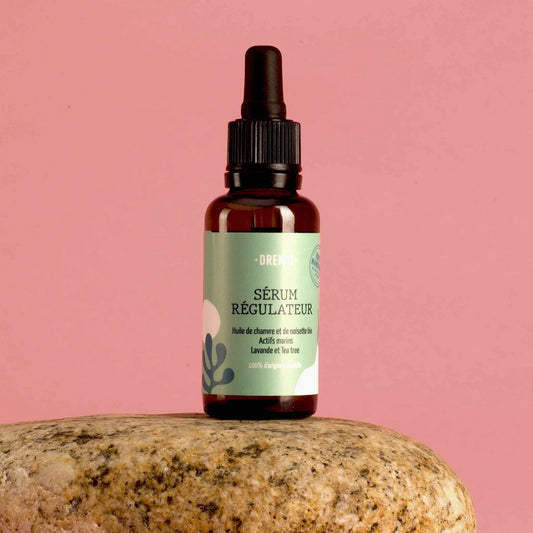 Le sérum visage régulateur aux actifs marins pour  les peaux mixtes à grasses sur un fond rose uni