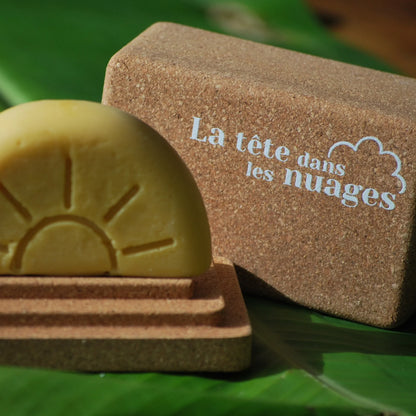 L'après-shampoing Alba sur la partie inférieure de la boite de transport et porte savon en liège pour solides rectangulaires